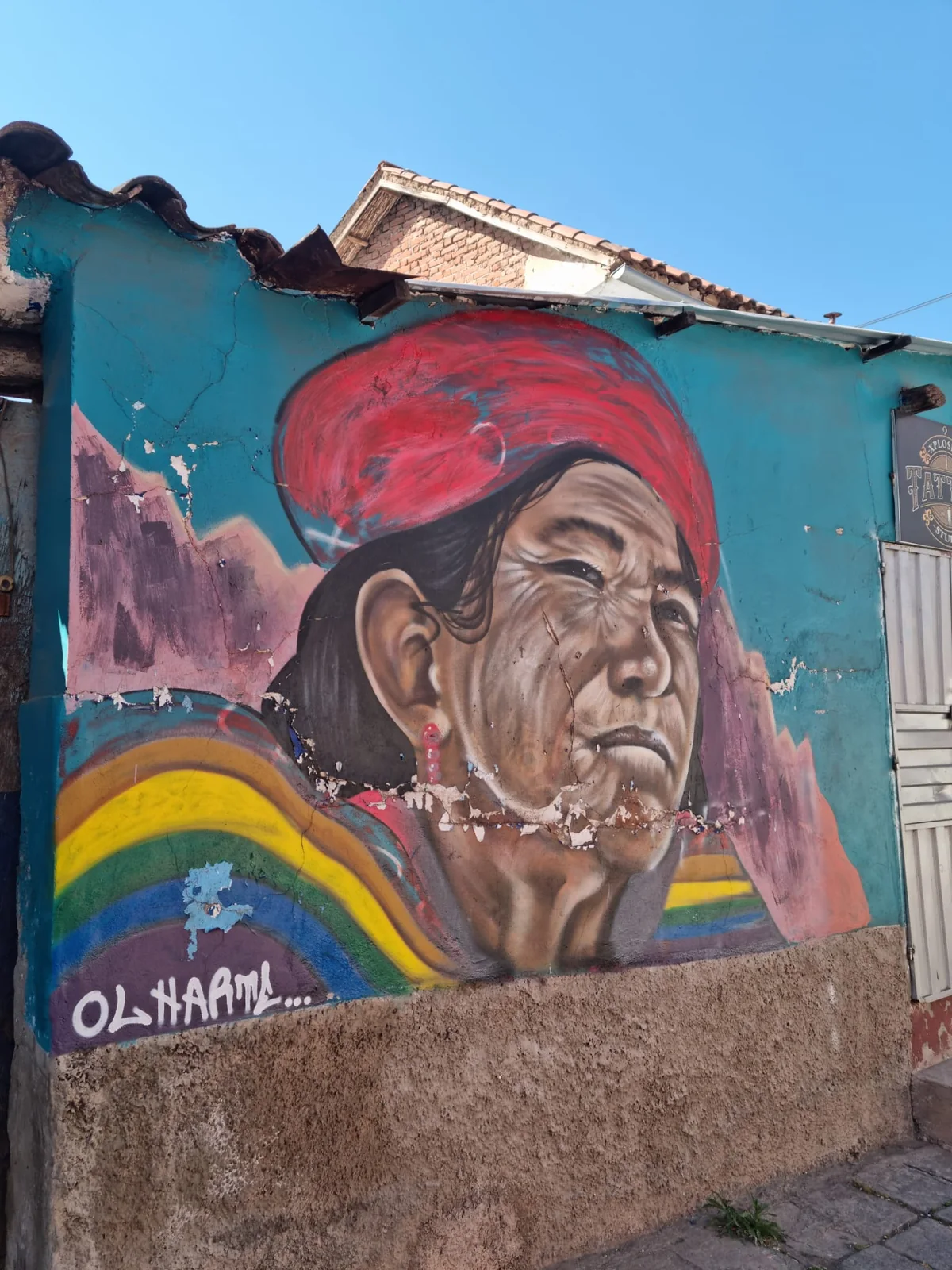 Murale con un volto dipinto sulla facciata di un edificio blu