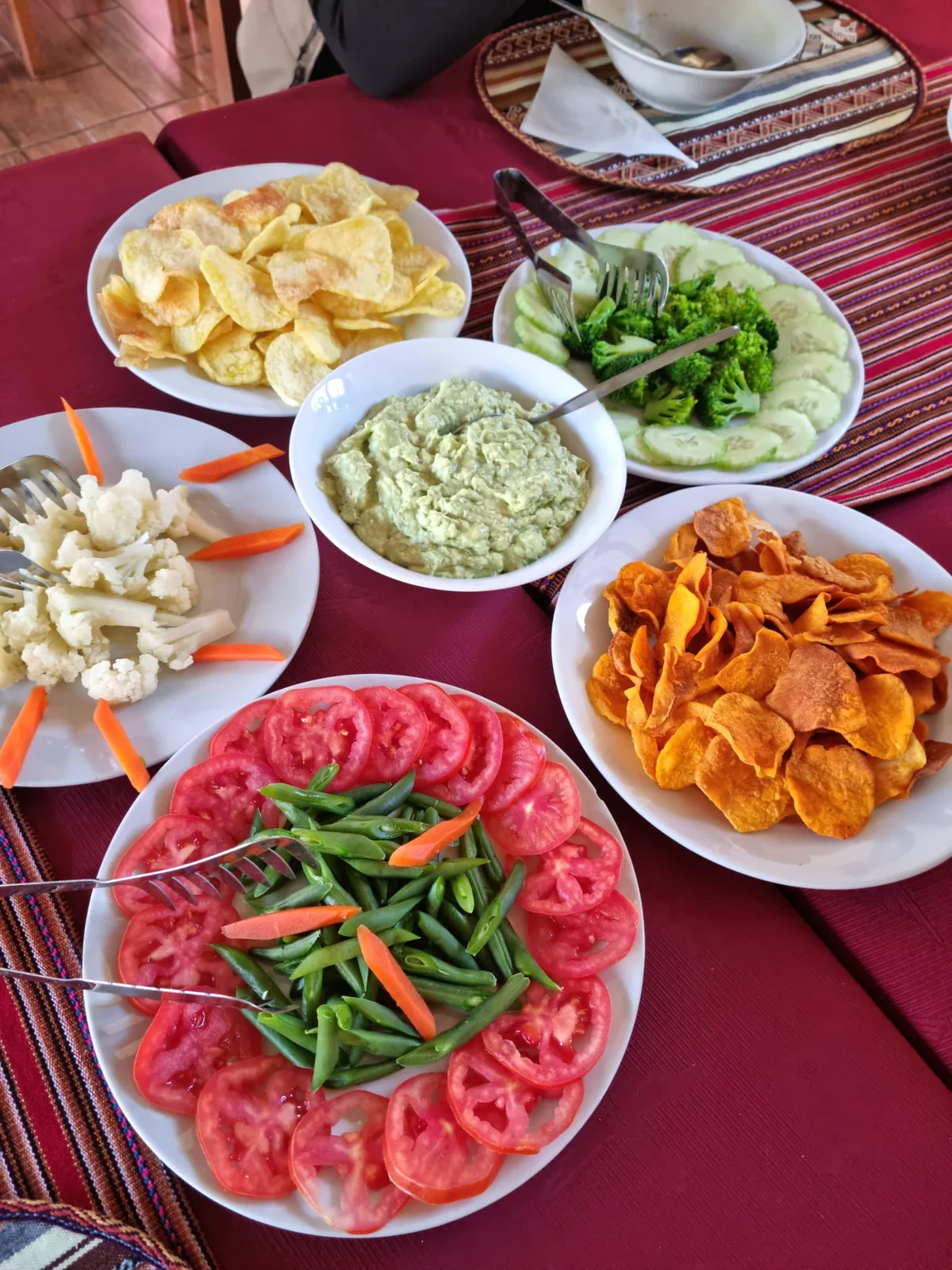 Tavola con verdure, patatine e salse fotografata durante il viaggio